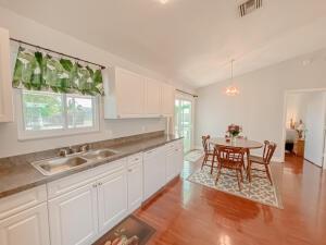 780 2nd Street Southwest Vero Beach, FL 32962 - Photo 4 of 21 a kitchen with granite countertop a stove a sink a dining table and chairs with wooden floor