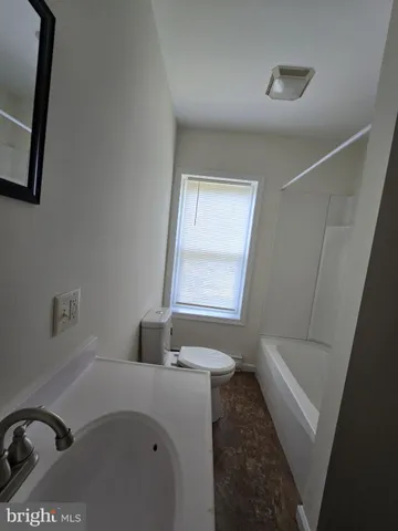a bathroom with a tub sink and mirror