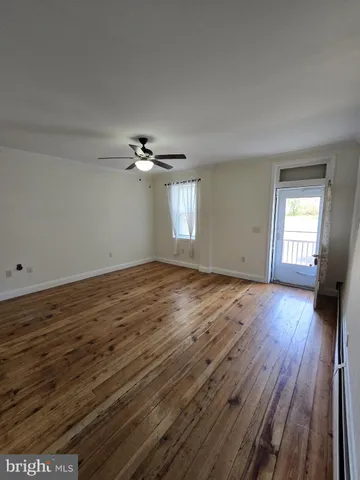 a view of a livingroom with wooden floor and window