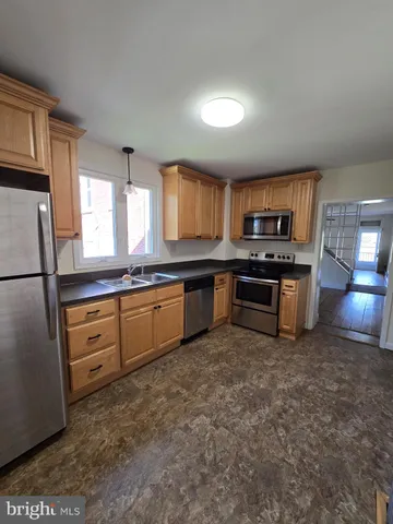 a kitchen with granite countertop a sink a counter top space stainless steel appliances and cabinets