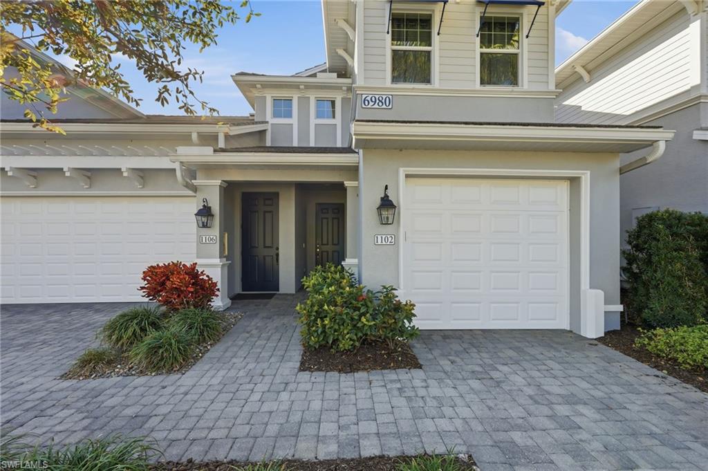 View of exterior entry featuring stucco siding, decorative driveway, and an attached garage