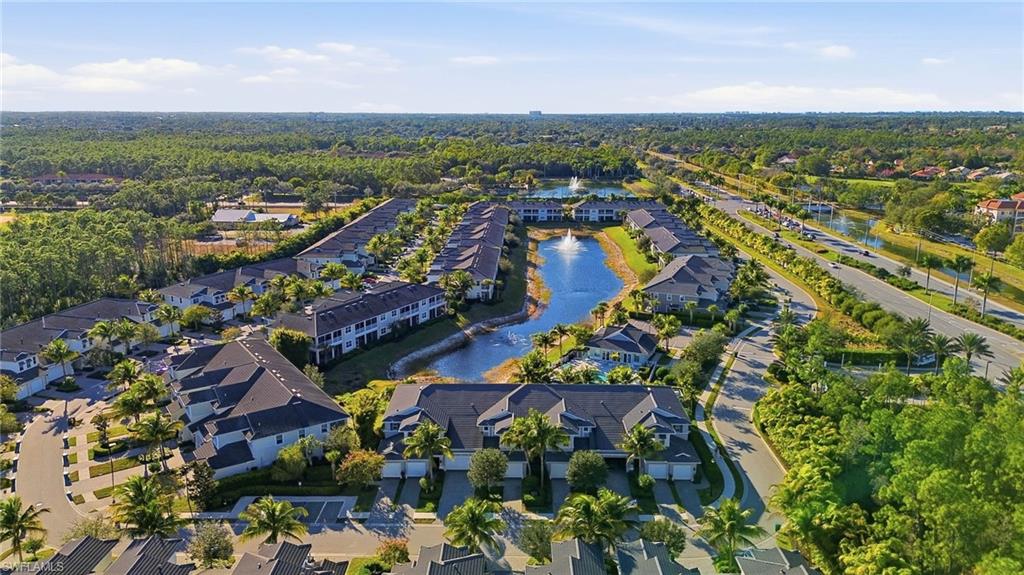 6980 Avalon Circle, Unit 1102 Naples, FL 34112 - Photo 18 of 24 Aerial view of property and surrounding area with a large body of water and nearby suburban area