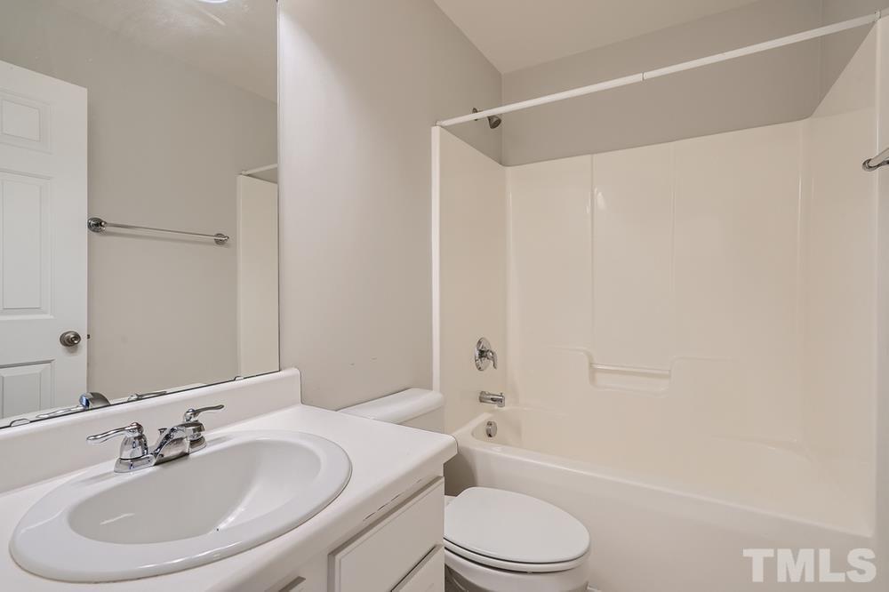 7222 Racine Way Raleigh, NC 27615 - Photo 22 of 27 a bathroom with a sink toilet and shower