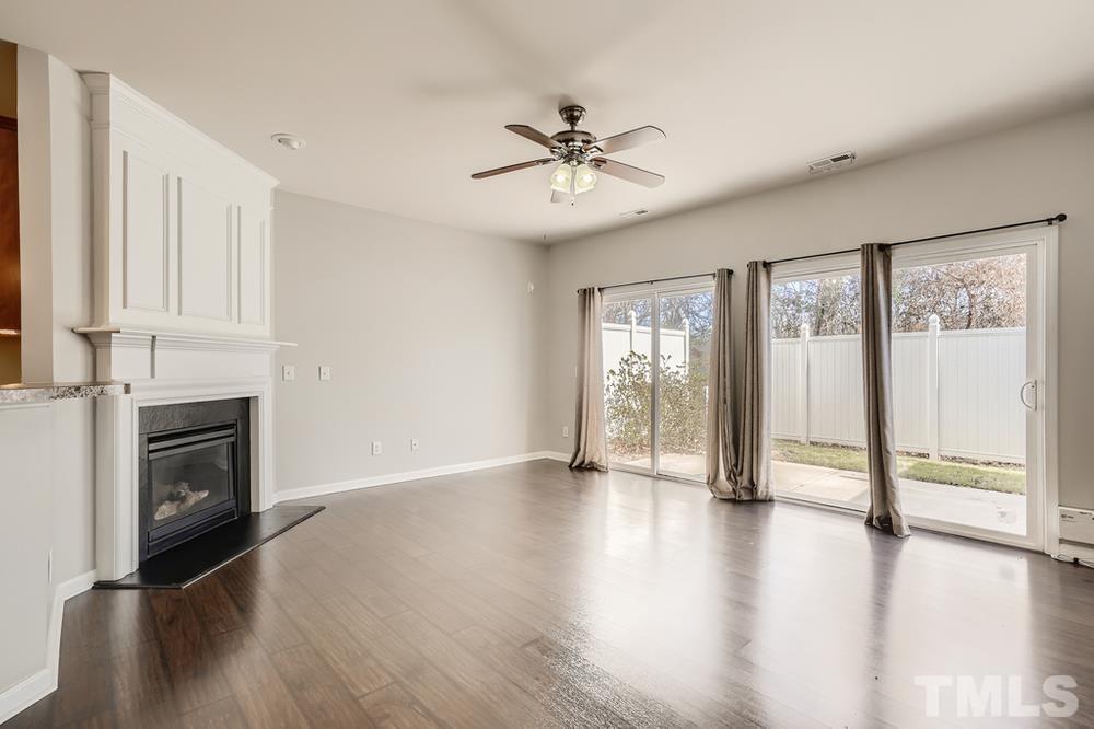 7222 Racine Way Raleigh, NC 27615 - Photo 7 of 27 a view of an empty room with a window and wooden floor