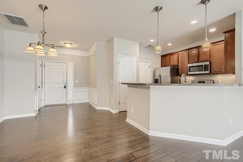 7222 Racine Way Raleigh, NC 27615 - Photo 9 of 27 a kitchen with kitchen island white cabinets and stainless steel appliances
