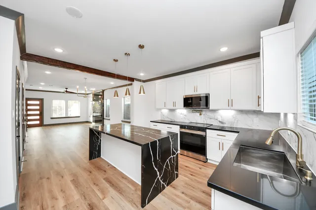 a kitchen with stainless steel appliances granite countertop a sink stove and refrigerator