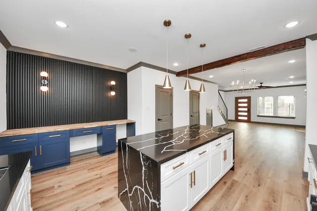 a large kitchen with a lot of counter space and wooden floor
