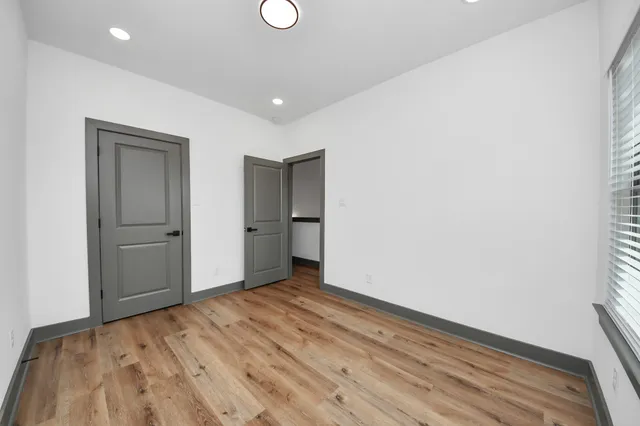 a view of empty room with wooden floor