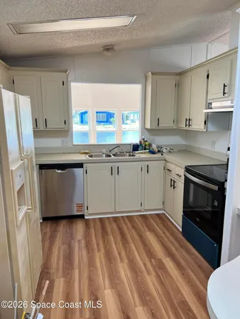 a kitchen with granite countertop a sink stainless steel appliances and cabinets