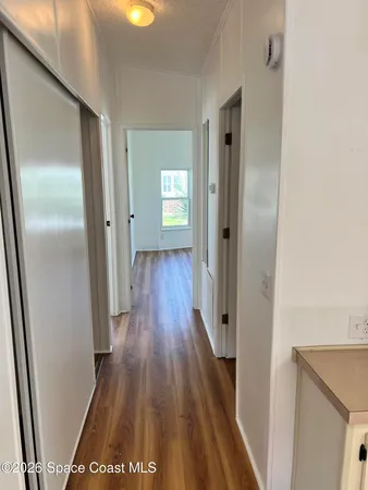 a view of a hallway with wooden floor
