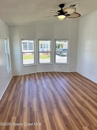 wooden floor in an empty room with a window