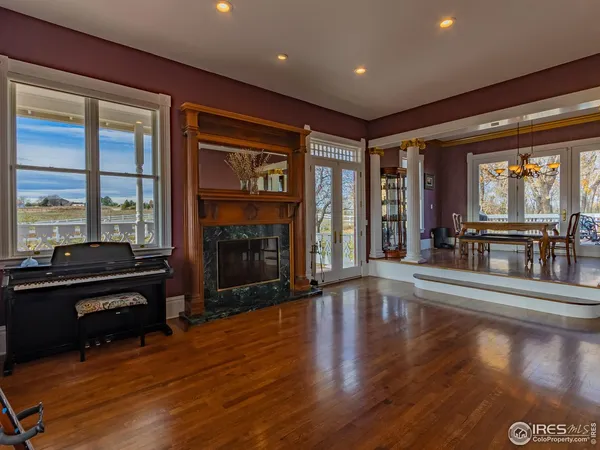 a dining room with furniture a chandelier and wooden floor