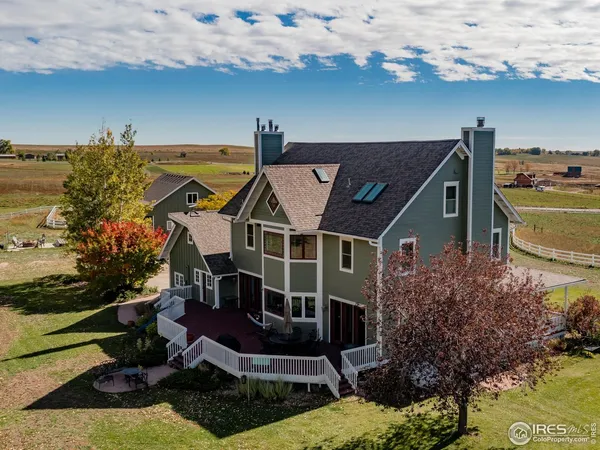 an aerial view of a house with swimming pool and outdoor seating