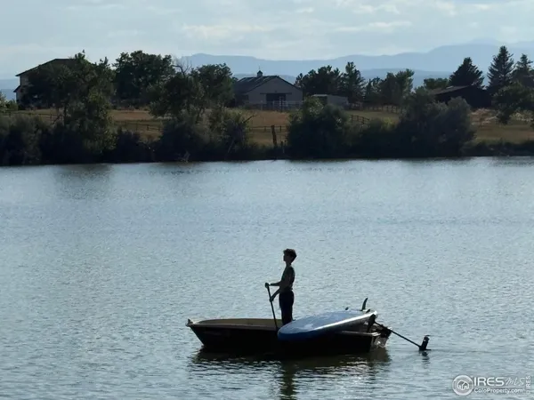 a view of swimming pool with outdoor seating and trees in the background