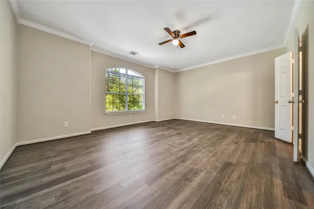 an empty room with wooden floor air conditioner and windows