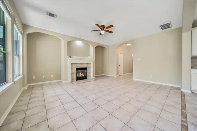 an empty room with windows and fireplace