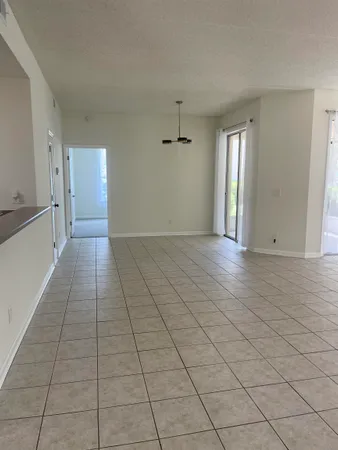 an empty room with a natural light and windows