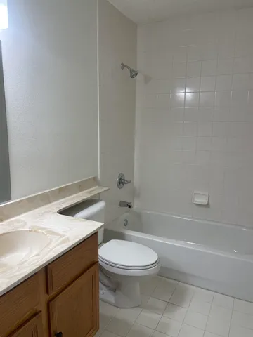 a bathroom with a granite countertop toilet a sink and bathtub