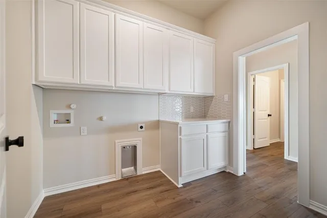 an empty room with wooden floor fireplace and windows