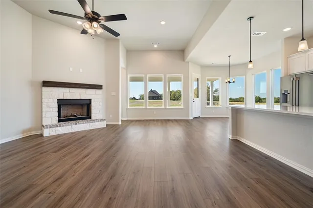a view of a kitchen and an empty room with a fireplace
