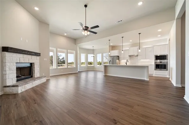 a kitchen with stainless steel appliances granite countertop a sink a stove and a wooden floors