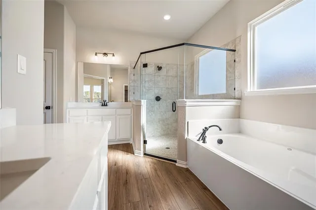 a view of a hallway with wooden floor windows and a bathroom