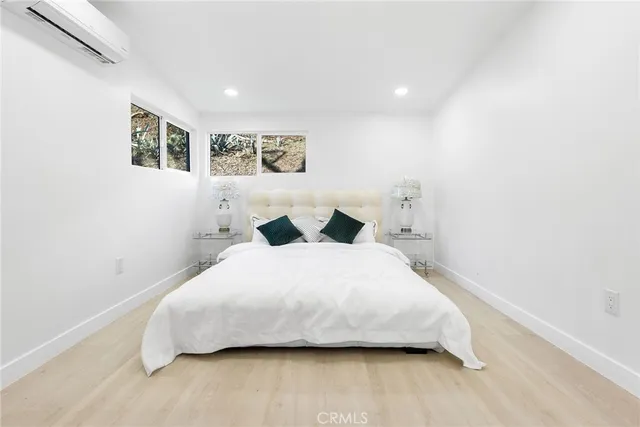 a bedroom with a bed and painting on the wall