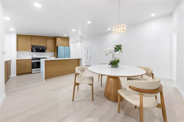 a living room with stainless steel appliances furniture a dining table and chairs