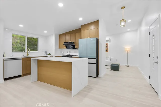a kitchen with stainless steel appliances a refrigerator sink and microwave