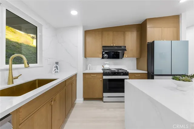 a kitchen with a sink a stove and a refrigerator
