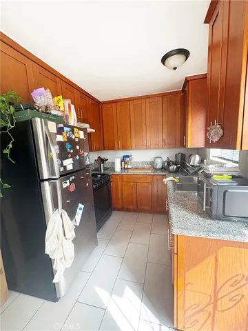 a kitchen with stainless steel appliances granite countertop a refrigerator and a stove top oven