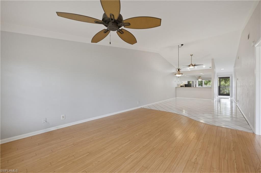 4031 Ice Castle Way, Unit 3306 Naples, FL 34112 - Photo 11 of 25 Unfurnished living room featuring light wood finished floors, ceiling fan, and vaulted ceiling