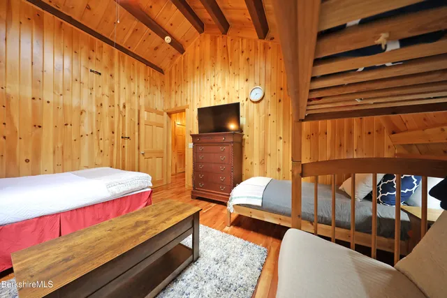 a bedroom with a bed and wooden floor