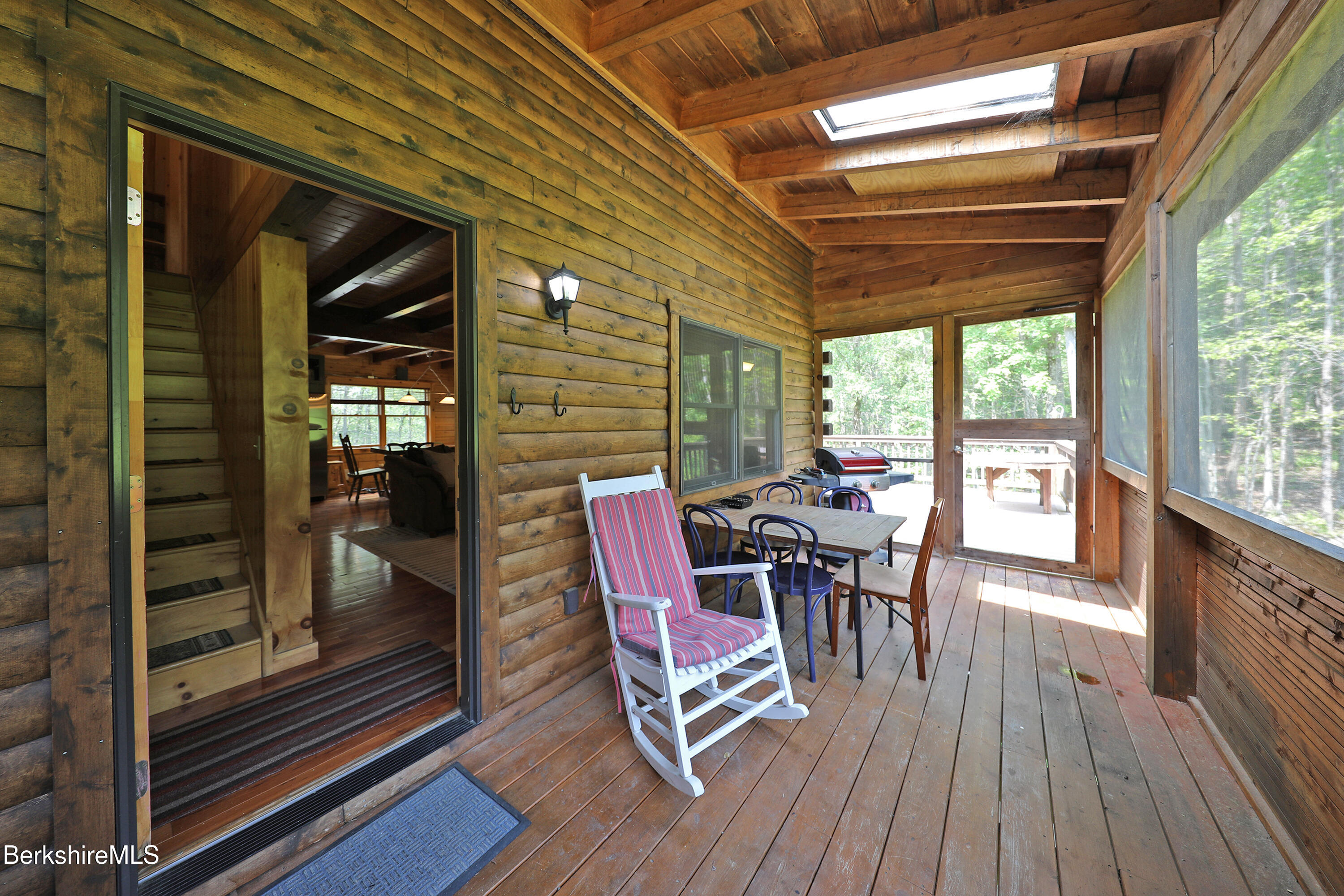 235 Algerie Road Becket, MA 01223 - Photo 6 of 43 a view of a deck with table and chairs with wooden floor and floor to ceiling window