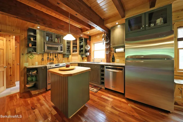 a kitchen with stainless steel appliances granite countertop a stove a sink and a refrigerator