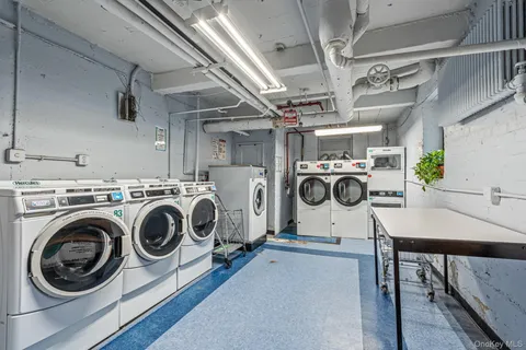 a utility room with dryer washer and stair