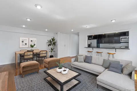 a living room with furniture a flat screen tv and kitchen view