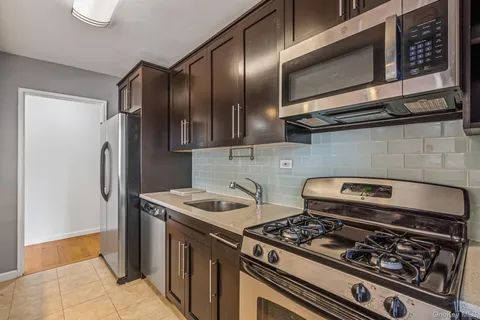 a kitchen with stainless steel appliances granite countertop cabinets and a stove top oven
