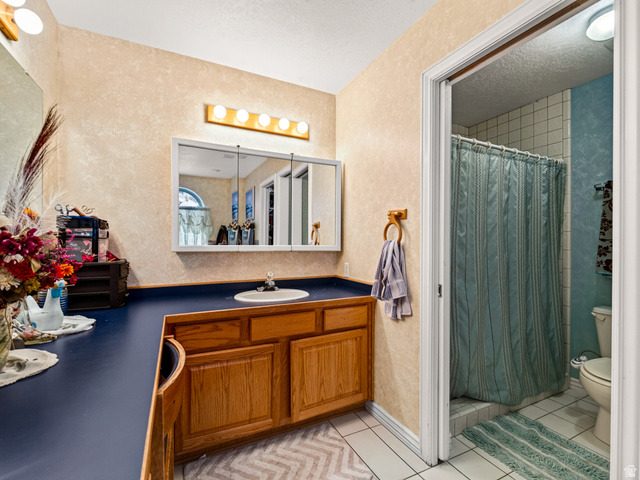 4380 Main Street Logan, UT 84321 - Photo 35 of 74 Primary bathroom with vanity, wood-finish cabinetry, integrated sink, and an overhead medicine cabinet with mirror