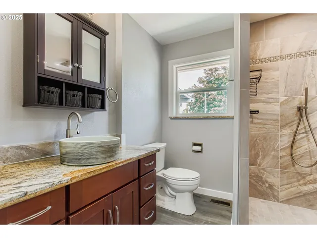 a bathroom with a granite countertop sink vanity and mirror