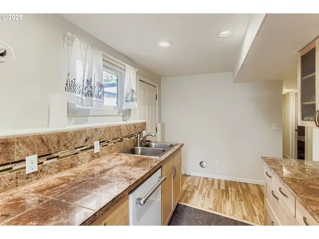 a kitchen that has a sink a stove and a refrigerator