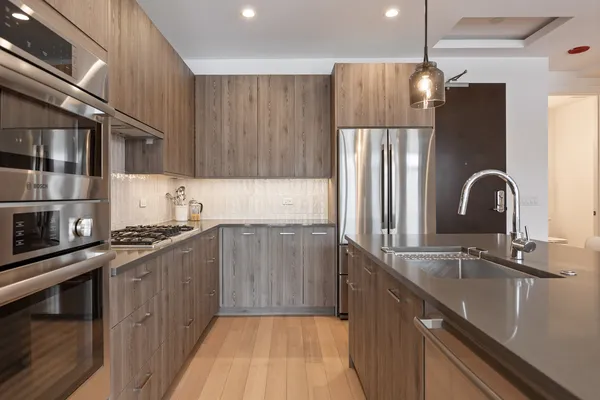 a kitchen with stainless steel appliances granite countertop a sink stove and refrigerator
