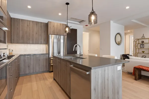 a kitchen with kitchen island granite countertop a sink stainless steel appliances and cabinets