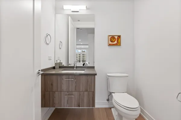 a bathroom with a granite countertop toilet a sink and mirror