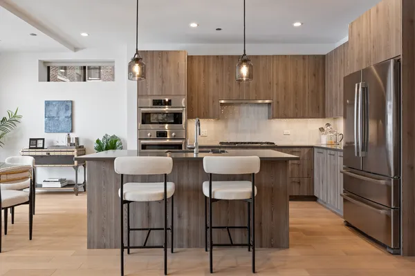 a kitchen with kitchen island stainless steel appliances a refrigerator and a stove top oven