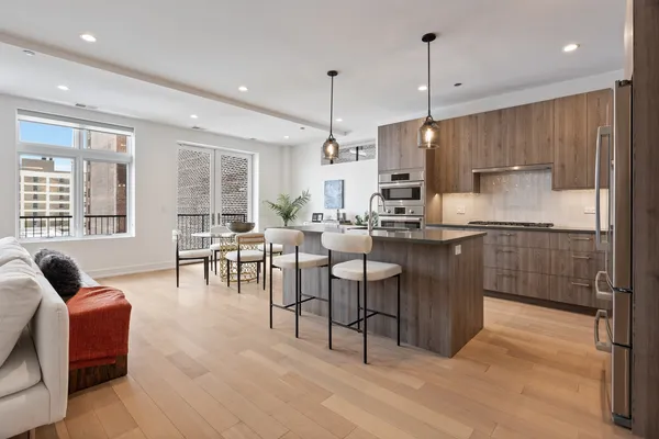 a kitchen with stainless steel appliances granite countertop a stove a sink a oven a dining table and chairs