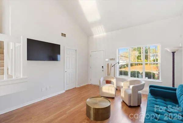 a living room with furniture a flat screen tv and a window