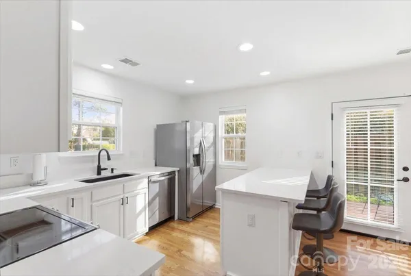 a kitchen with kitchen island a sink stainless steel appliances and window