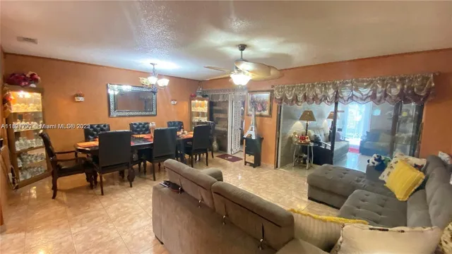 a living room with furniture a chandelier and a dining table