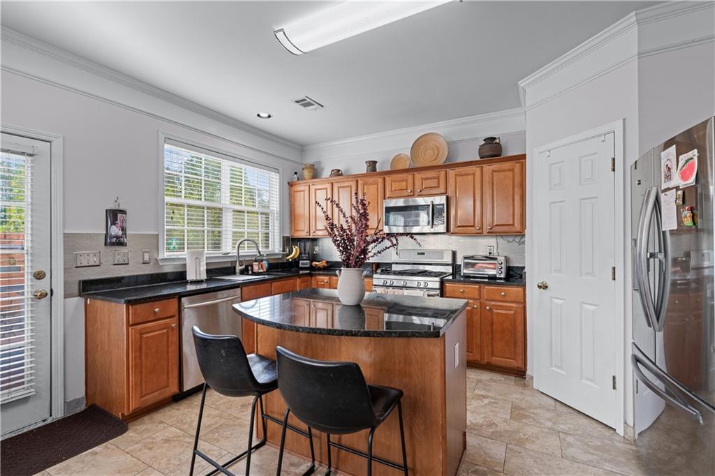 135 Splinter Court Suwanee, GA 30024 - Photo 14 of 47 a kitchen with stainless steel appliances granite countertop a stove a sink dishwasher and a refrigerator with wooden cabinets